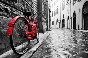 Retro vintage red bike on cobblestone street in the old town. Color in black and white