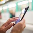 Woman using her cell phone on subway platform