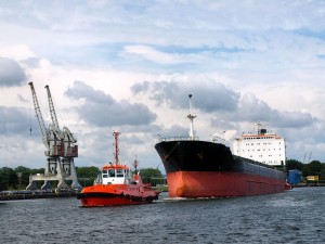 5257707 - red tug is towing the vessel in port.