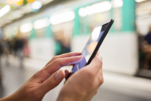 Woman using her cell phone on subway platform